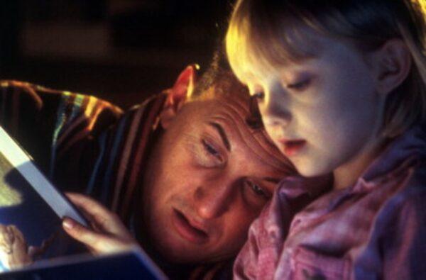 Sam (Sean Penn) and Lucy (Dakota Fanning), his daughter, read together in "I Am Sam." (New Line Cinema)