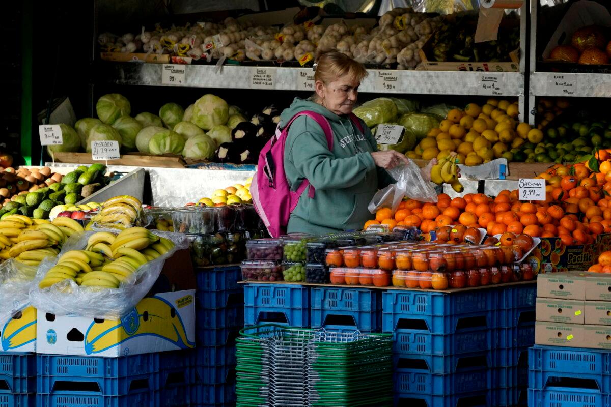 A woman selects fruit at a supermarket in London on Nov. 17, 2021. (Frank Augstein, File/AP Photo)