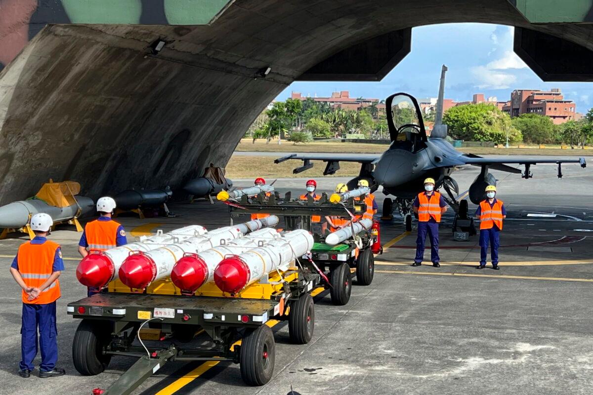 Military personnel stand next to Harpoon A-84, anti-ship missiles and AIM-120 and AIM-9 air-to-air missiles prepared for a weapon loading drills in front of a F16V fighter jet at the Hualien Airbase in Taiwan's southeastern Hualien county on Aug. 17, 2022. (AP Photo/Johnson Lai)