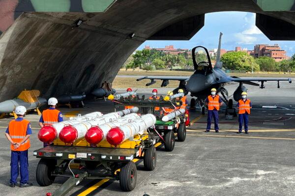Military personnel stand next to Harpoon A-84, anti-ship missiles, and AIM-120 and AIM-9 air-to-air missiles prepared for a weapon loading drills in front of a F16V fighter jet at the Hualien Airbase in Taiwan's southeastern Hualien county on Aug. 17, 2022. (AP Photo/Johnson Lai)