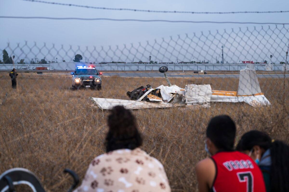 People look at the wreckage from a plane crash at Watsonville Municipal Airport in Watsonville, Calif., on Aug. 18, 2022. (Nic Coury/AP Photo)