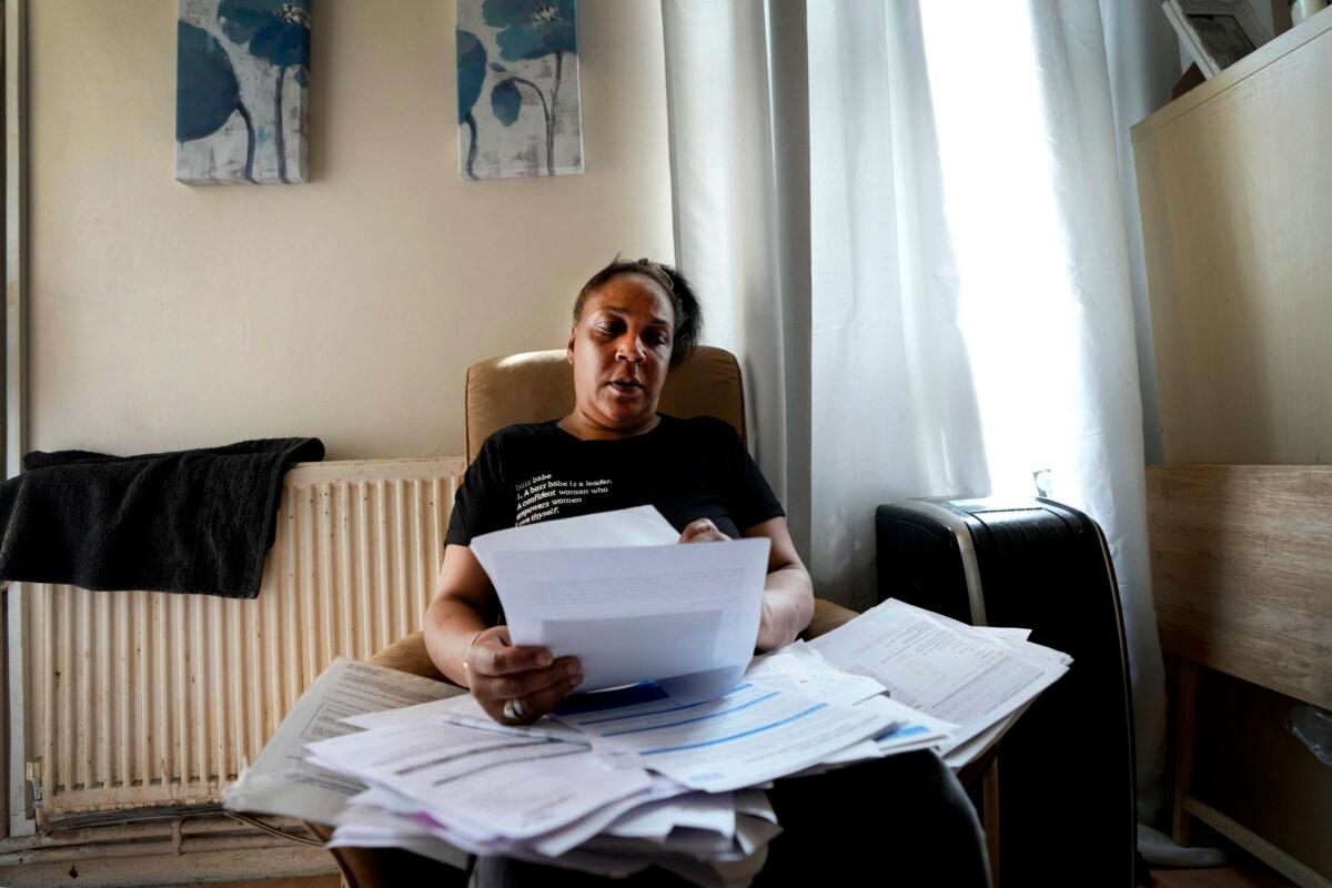 Jennifer Jones sorts her bills at her small flat in London, on Aug. 25, 2022. Like millions of people, Jones, 54, is struggling to cope as energy and food prices skyrocket during Britain's worst cost-of-living crisis in a generation. (Frank Augstein/AP Photo)