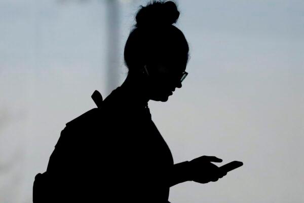 A woman checks her phone in Orem, Utah, on Nov. 14, 2019. A survey of people ages 16–40 finds that millennials and Generation Z follow the news, but they aren't that happy with what they're seeing. The study conducted by The Associated Press-NORC Center for Public Affairs Research and the American Press Institute says 79 percent of people follow news daily, contrary to perceptions that many are tuned out. (AP Photo/Rick Bowmer/File)