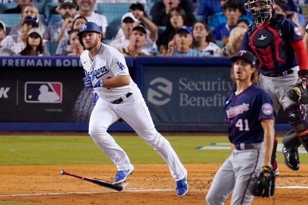 Los Angeles Dodgers' Max Muncy, left, heads to first as he hits a solo home run while Minnesota Twins starting pitcher Joe Ryan, center, and catcher Sandy Leon watch during the third inning of a baseball game in Los Angeles Tuesday, August 9, 2022. (Mark J. Terrill/AP Photo)