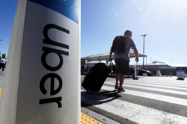 A passenger walks near Uber signage after arriving at Los Angeles International Airport (LAX) in Los Angeles, Calif., on July 10, 2022. (David Swanson/REUTERS)
