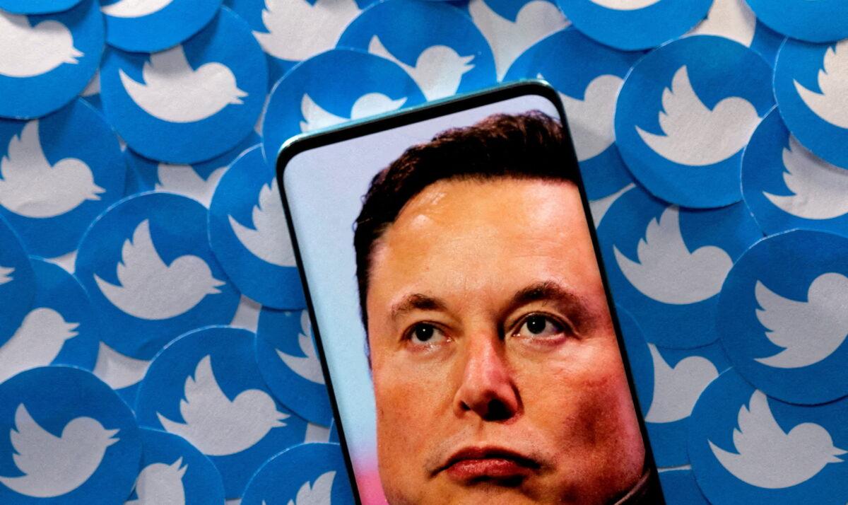 An image of Elon Musk is seen on smartphone placed on printed Twitter logos in this picture illustration taken on April 28, 2022. (Dado Ruvic/Illustration/Reuters)