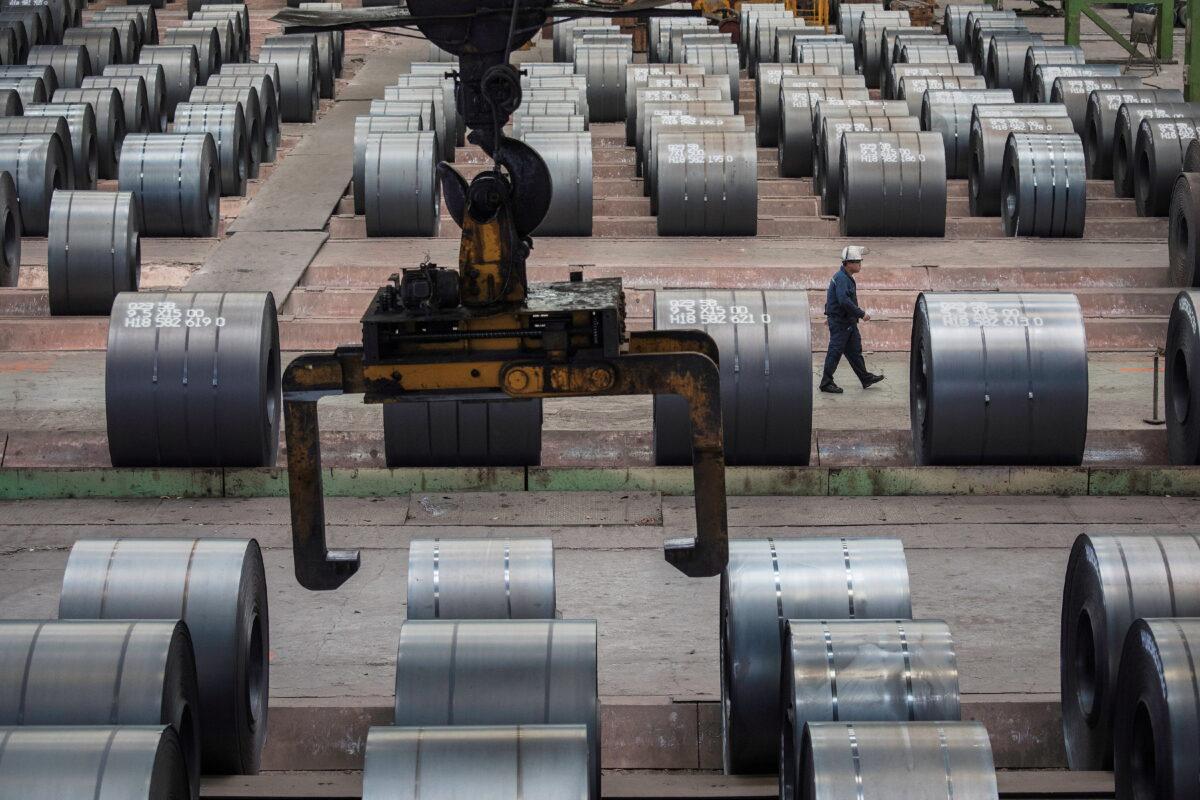 A worker walks past steel rolls at the Chongqing Iron and Steel plant in Changshou, Chongqing, China, on Aug. 6, 2018. (Damir Sagolj/Reuters)