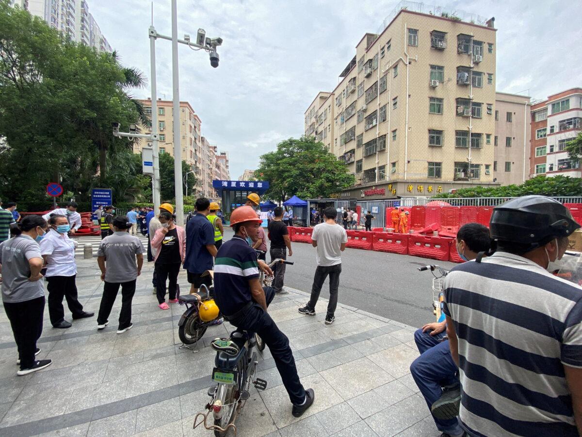 People watch as barricades are set up outside an entrance to Wanxia urban village as part of COVID-19 measures in Shenzhen, Guangdong province, China, on Aug. 29, 2022. (David Kirton/Reuters)