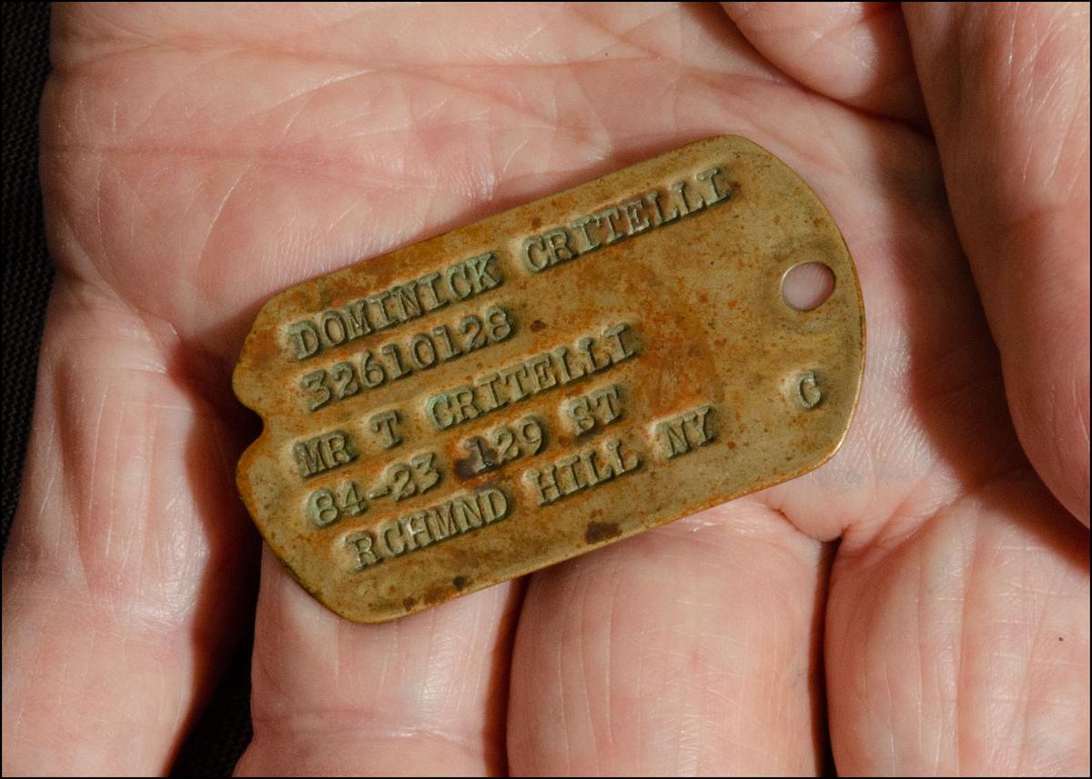 Critelli holds his one-surviving dog tag from his service in World War II. (Dave Paone/The Epoch Times)