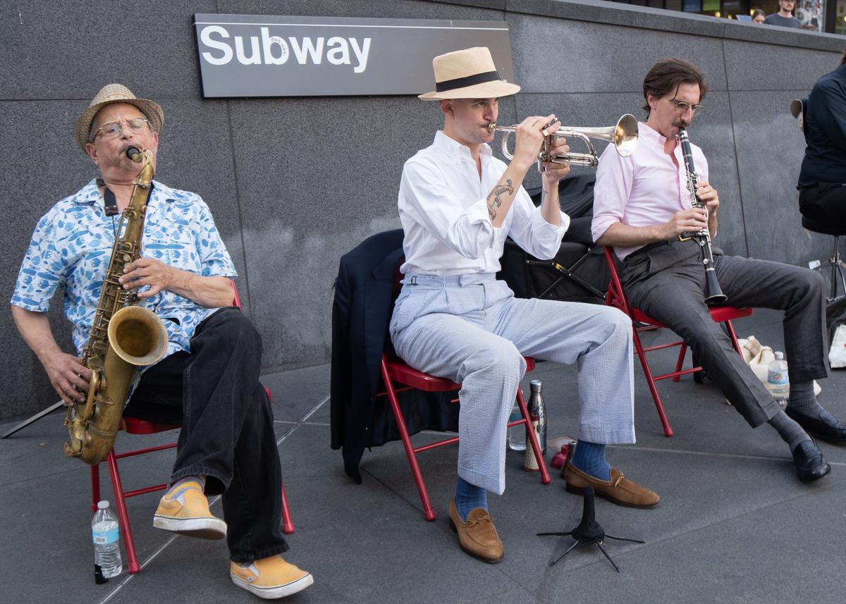 As part of the 34th Street Partnership, the Gotham City Band performs a free concert outside of the Moynihan Train Hall in New York City, with (L-R) Mike Hashim, Mike Davis, and Ricky Alexander. (Dave Paone/The Epoch Times)