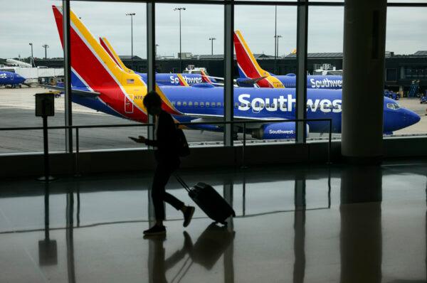A traveler walks past a Southwest Airlines airplane as it taxies from a gate at Baltimore Washington International Thurgood Marshall Airport in Baltimore, Maryland, Oct. 11, 2021. (Kevin Dietsch/Getty Images)