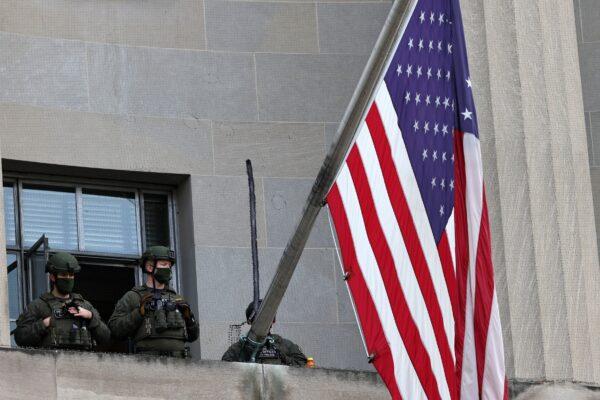 Federal law enforcement officers stand guard at the Department of Justice building in Washington, D.C., on Jan. 17, 2021. (Michael M. Santiago/Getty Images)