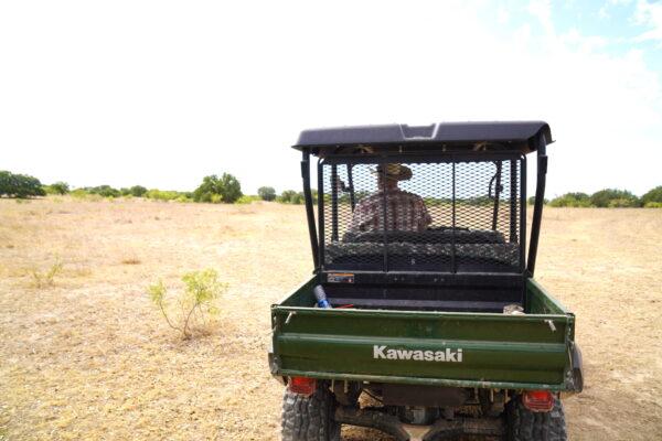 Cross Plains cattle rancher Kyle Foster rides a Kawasaki all-terrain vehicle to get around his 5,000-acre Texas property on Aug. 9, 2022. (Allan Stein/The Epoch Times)