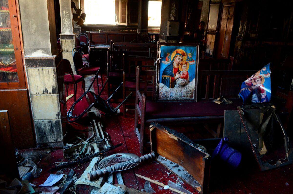Burned furniture, including wooden tables and chairs, and a religious image at the site of a fire inside the Abu Sefein Coptic church in the neighborhood of Imbaba, Cairo, Egypt, on Aug. 14, 2022. (Tarek Wajeh/AP Photo)
