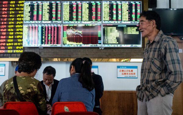 An investor looks at an electronic board showing stock information at a brokerage house in Shanghai, China, on Oct. 15, 2018. (JOHANNES EISELE/AFP via Getty Images)