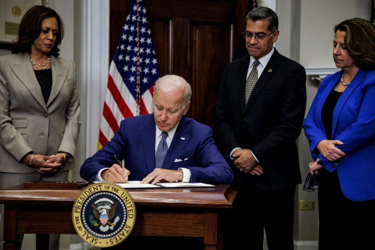 President Joe Biden signs an executive order directing the Department of Health and Human Services to ensure access to abortions while Vice President Kamala Harris, HHS Secretary Xavier Becerra, and Deputy Attorney General Lisa Monaco look on at the White House in Washington, on July 8, 2022. (Samuel Corum, AFP/Getty Images)