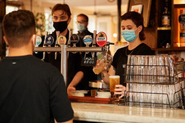 Staff pour drinks at a hotel bar in Perth, Australia, on Feb. 5, 2021. (Stefan Gosatti/Getty Images)
