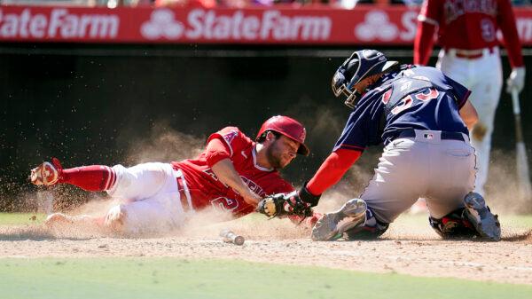 Los Angeles Angels' David Fletcher, left, is tagged out at home plate by Minnesota Twins catcher Sandy Leon on a fielder's choice after a ground ball by Luis Rengifo during the seventh inning of a baseball game in Anaheim, Calif., on Aug. 14, 2022. (Marcio Jose Sanchez/AP Photo)