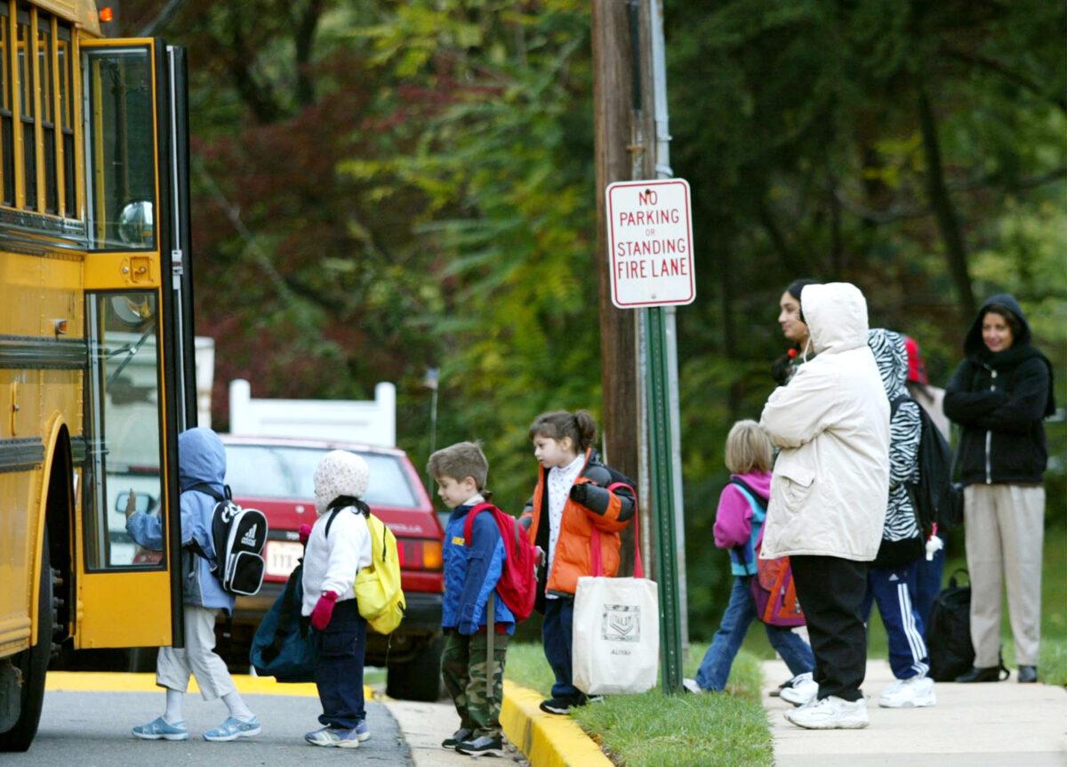 Parents watch children step onto a Fairfax County school bus in Falls Church, Va., on Oct. 15, 2002. (Mark Wilson/Getty Images)