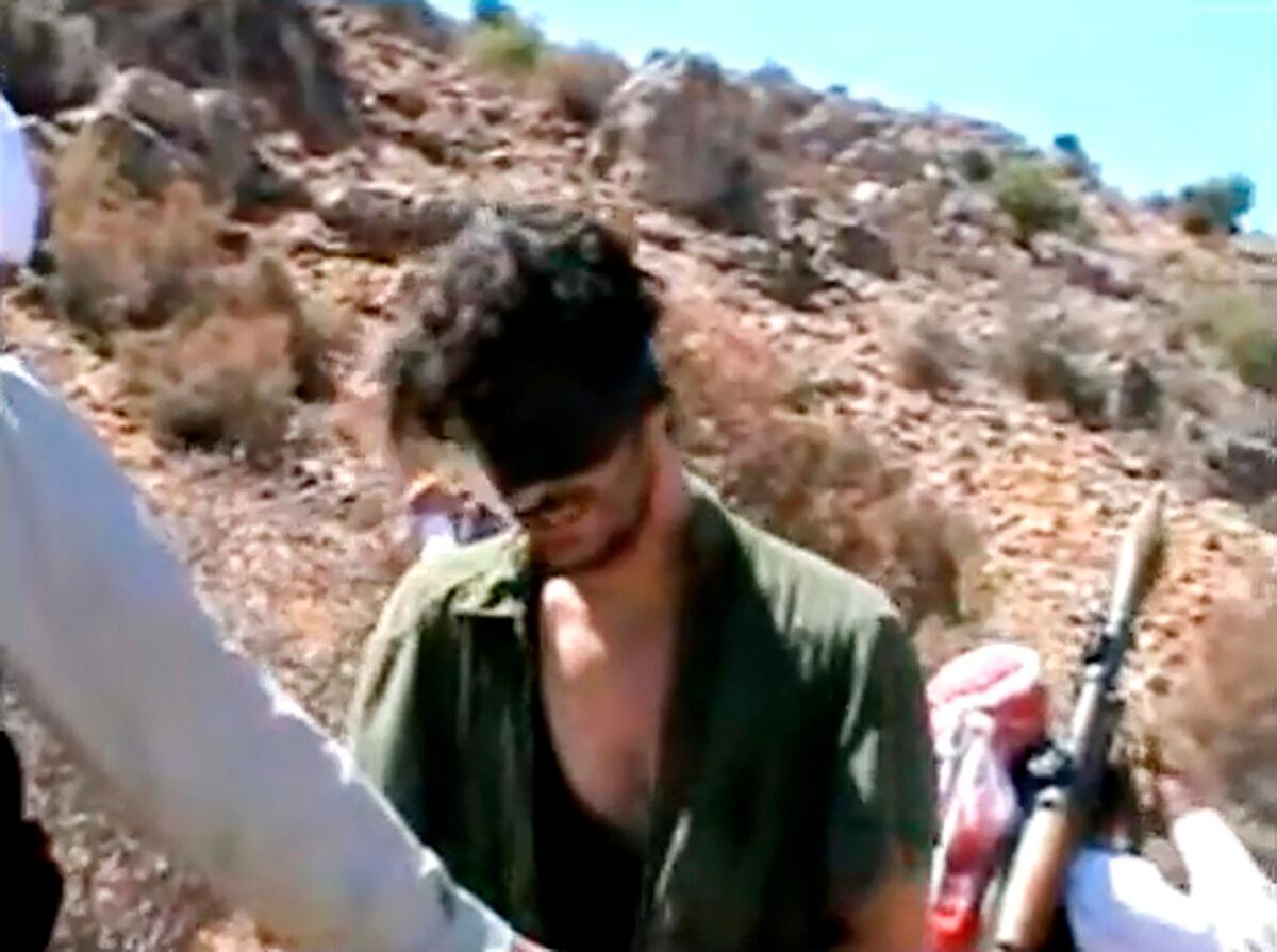 American freelance journalist Austin Tice, who had been reporting for American news organizations in Syria until his disappearance in August 2012, prays in Arabic and English while blindfolded in the presence of gunmen, in a still from undated video posted to YouTube. (AP Photo)