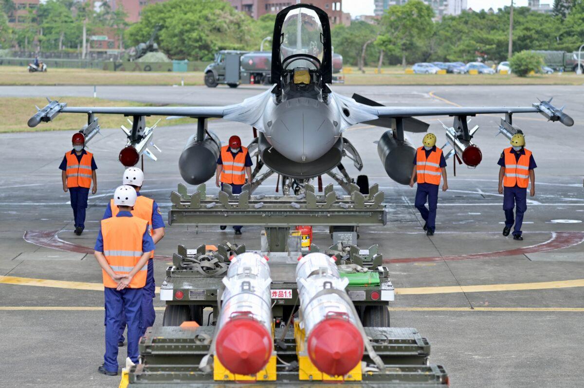 Air Force soldiers clear the ground in front of an armed F-16V fighter jet during a drill at Hualien Air Force base in Hualien County, Taiwan, on Aug. 17, 2022. (Sam Yeh/AFP via Getty Images)