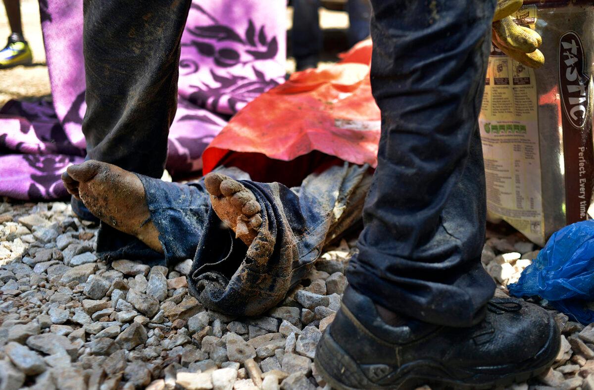 The body of a miner lies on the ground after being pulled out at an illegal gold mine in Benoni, outside Johannesburg, on Feb. 18, 2014. (Mujahid Safodien/AFP via Getty Images)