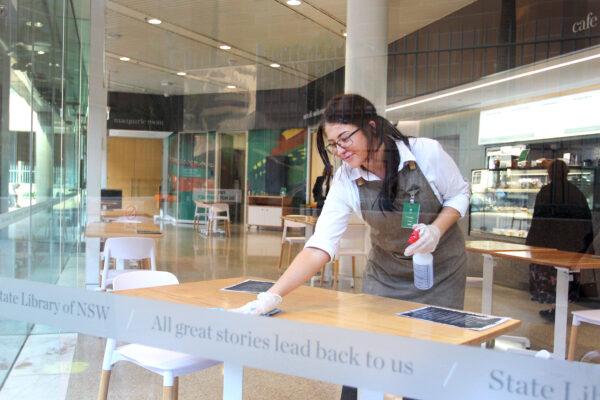 A cafe staff member wipes a table at the State Library of New South Wales in Sydney, Australia, on June 1, 2020. (Lisa Maree Williams/Getty Images)