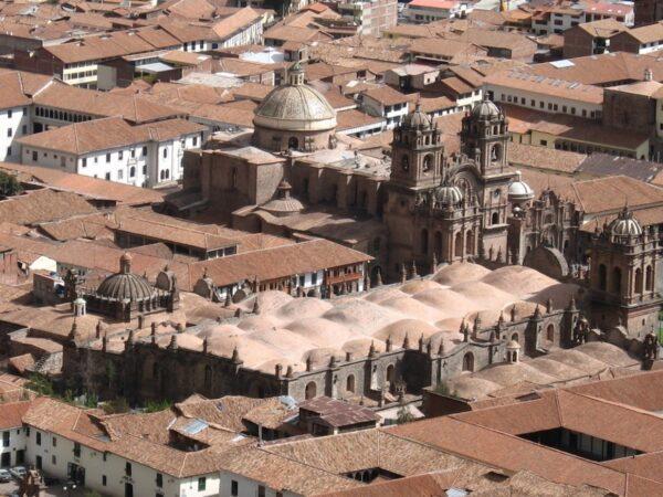 An aerial view of the Cusco Cathedral nestled in the Peruvian Andes. The cathedral is located on the Plaza de Armas (main square), and is connected to the Iglesia del Triunfo (Church of Triumph), the first Christian church built in Cusco, and the Iglesia de la Compañía de Jesús (Church of the Society of Jesus). Both churches were constructed around the same time as the Cusco Cathedral. (Colin W/<a href="https://en.wikipedia.org/wiki/Cusco_Cathedral#/media/File:Cusco,_Peru_-_panoramio_-_Colin_W.jpg">CC BY 3.0</a>)