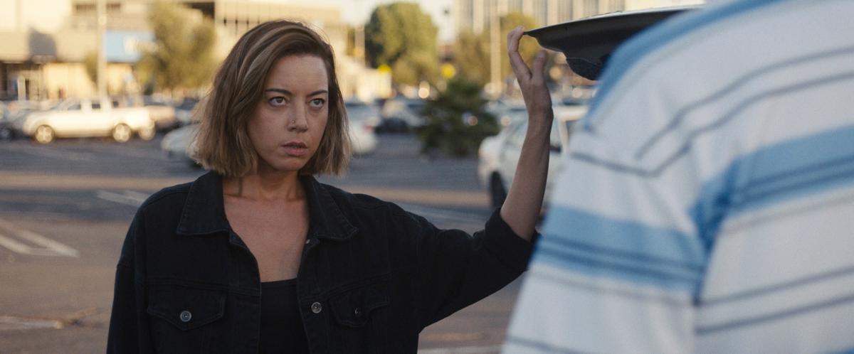 Emily (Aubrey Plaza) buying a luxury vehicle she needs to drive away in eight minutes, before the sellers figure out the credit card is fake, in "Emily the Criminal." (Roadside Attractions/Universal Pictures)