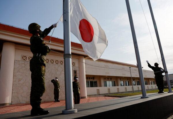 Members of the Japan Ground Self-Defense Force (JGSDF) bring down the Japanese national flag in the early evening, at JGSDF Miyako camp on Miyako Island, Okinawa prefecture, Japan April 20, 2022. (Issei Kato/Reuters)