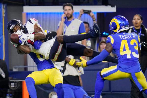 Houston Texans wide receiver Nico Collins, top center, makes a touchdown between Los Angeles Rams cornerback Derion Kendrick, bottom left, and safety Russ Yeast II (43) during the first half of a preseason NFL football game in Inglewood, Calif. on Aug. 19, 2022. (Jae C. Hong/AP Photo)