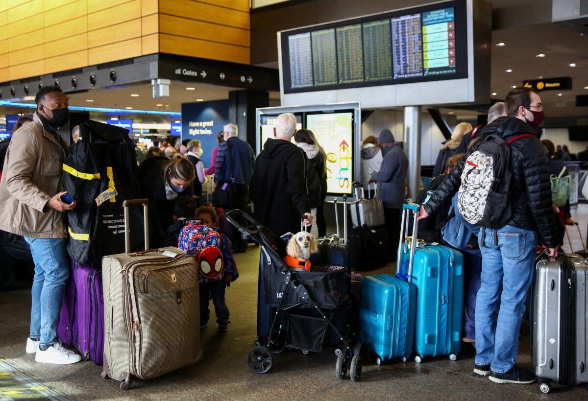 People wait in long check-in lines after dozens of flights were listed as canceled or delayed at Seattle-Tacoma International Airport in Seattle on Dec. 27, 2021. (Lindsey Wasson/Reuters)