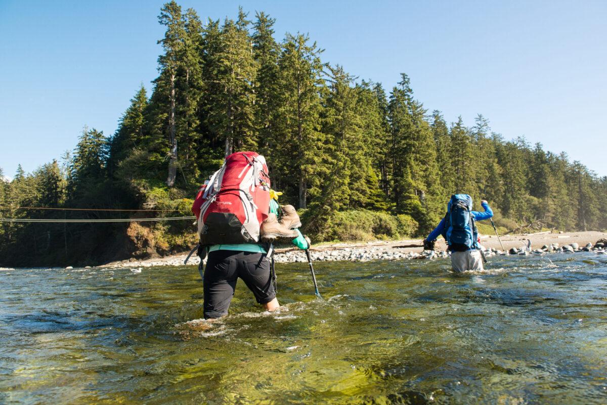 These two hikers opt for wading across Carmanah Creek, one of many creek crossings along the West Coast Trail. Pacific Rim National Park Reserve. (Parks Canada / Scott Munn)