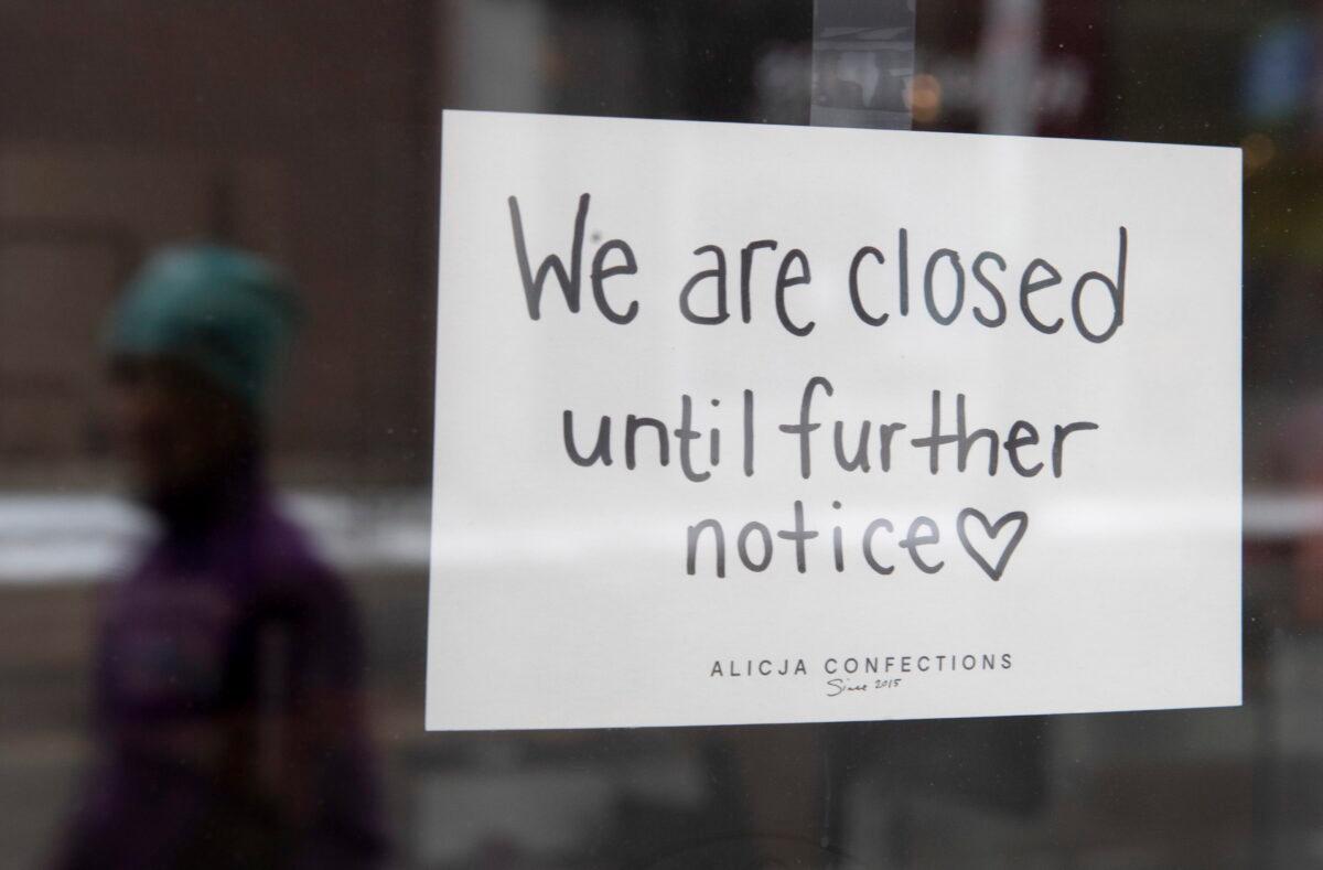 A sign on a shop window indicates the store is closed amid the pandemic, on March 23, 2020. (The Canadian Press/Adrian Wyld)