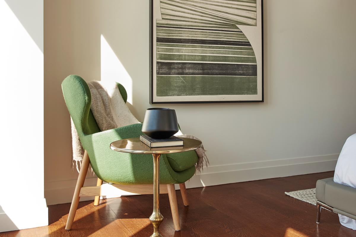 An oversized green accent chair makes a bold statement in a master bedroom. (Scott Gabriel Morris/TNS)