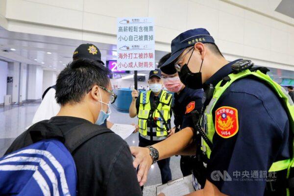 Policemen at Taoyuan International Airport talk a passenger out of boarding a flight to Cambodia under a government campaign to tackle human trafficking, on Aug. 1, 2022. (Courtesy of CNA)