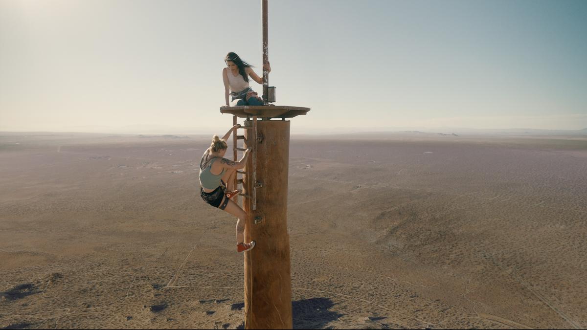 Shiloh Hunter (Virginia Gardner, L) attempts to lower off to retrieve a dropped backpack containing supplies that got hung up on archaic satellite dishes 100 feet below the observation deck, in “Fall." (Lionsgate)