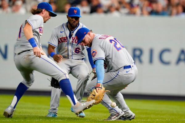 New York Mets' Jeff McNeil (1) and Starling Marte (6) watch as first baseman Pete Alonso (20) loses control of a ball hit by New York Yankees' Jose Trevino during the seventh inning of a baseball game in New York, Aug. 23, 2022. (Frank Franklin II/AP Photo)