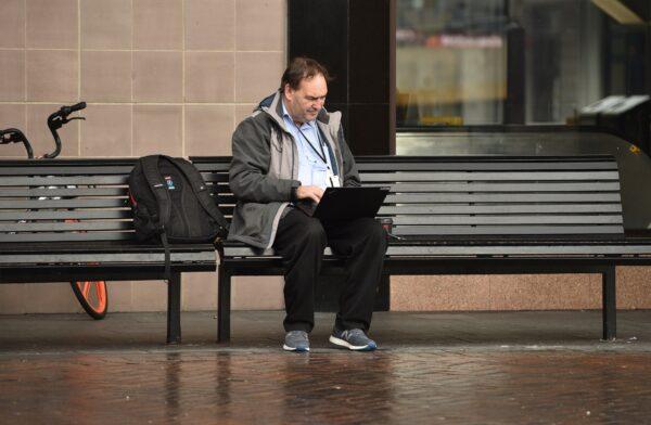 A man works on his laptop computer on a street in Sydney, Australia, on May 15, 2020. (Peter Parks/AFP via Getty Images)