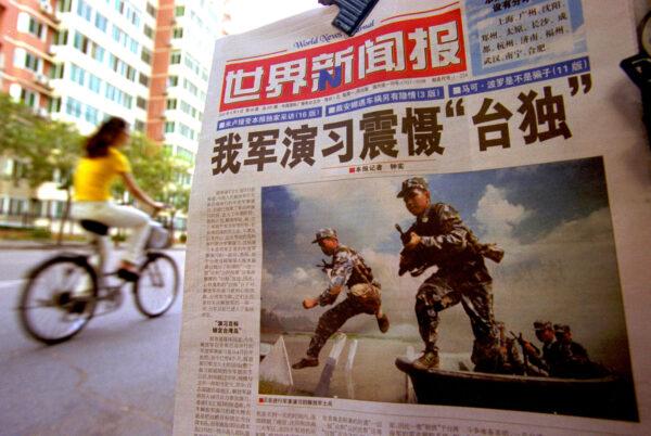 A newspaper features the People's Liberation Army (PLA) soldiers in a military exercise with the headline "Chinese Military Exercise Frightens Pro-Independence," in Beijing, on Aug. 7, 2002. (Kevin Lee/Getty Images)