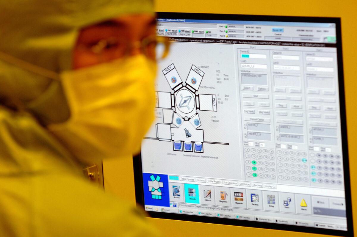 An engineer of United Microelectronics Corp (UMC) checks a monitor in the yellow light area at the 12-inch UMC wafer factory in Tainan Science Park, southern Taiwan, 28 April 2006. (Sam Yeh/AFP via Getty Images)