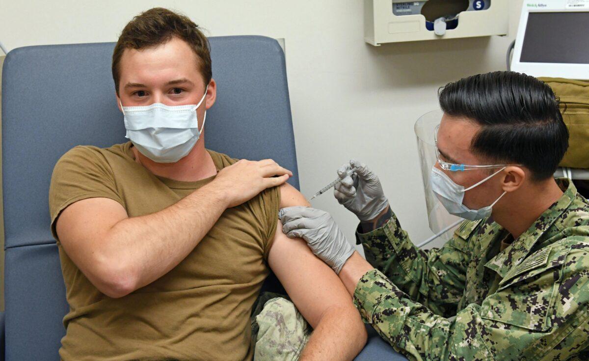 A hospital corpsman administers a COVID-19 vaccine to a fellow corpsman at Naval Health Clinic Hawaii on Dec. 16, 2020. (Naval Health Clinic Hawaii)