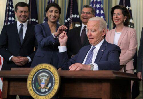 President Joe Biden passes a signing pen to Chairperson of the Federal Trade Commission Lina Khan (2nd L) as (L-R) Secretary of Transportation Pete Buttigieg, Secretary of Health and Human Services Xavier Becerra, and Secretary of Commerce Gina Raimondo look on during an event at the State Dining Room of the White House in Washington on July 9, 2021. (Alex Wong/Getty Images)