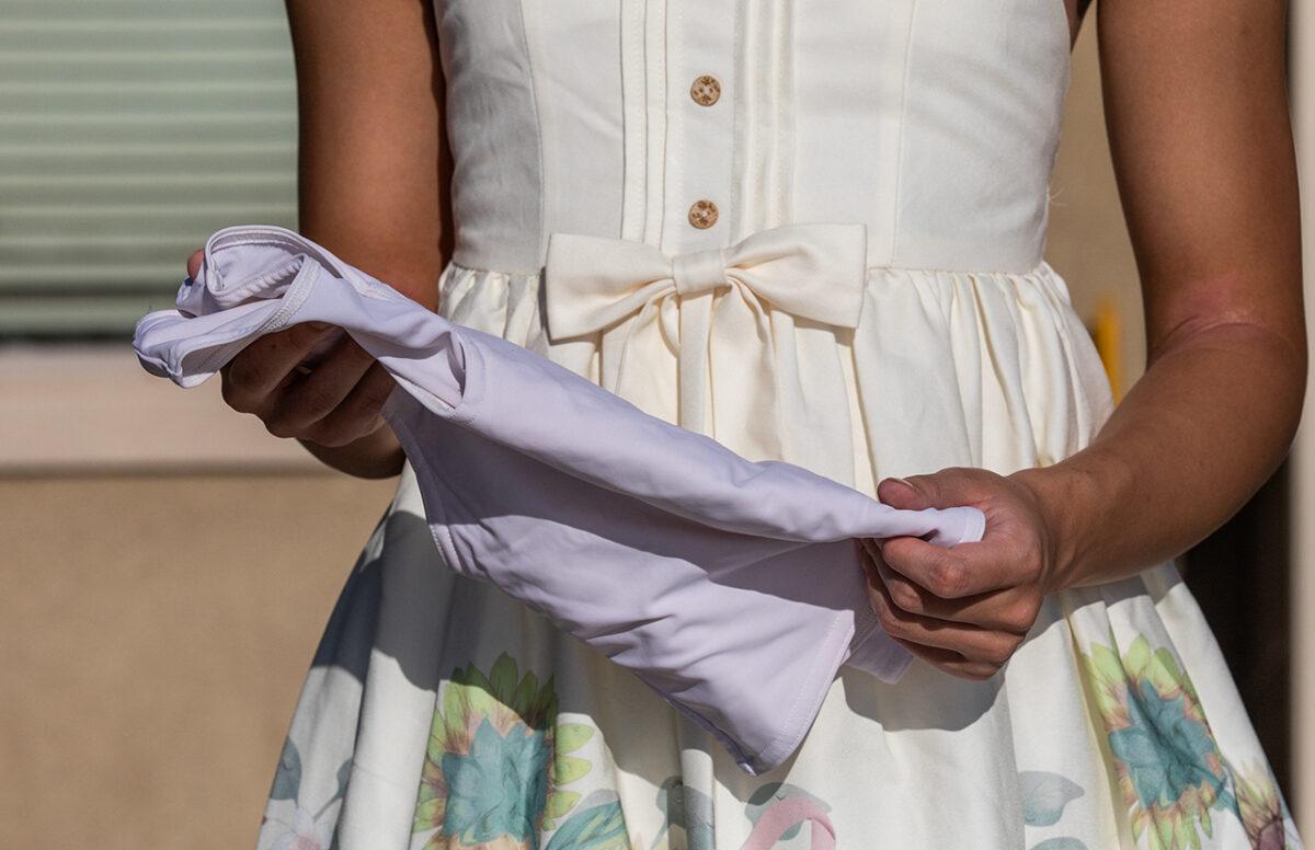 A teen holds a binder that she used while she was taking transgender hormonal treatments, in Northern California on Aug. 26, 2022. (John Fredricks/The Epoch Times)