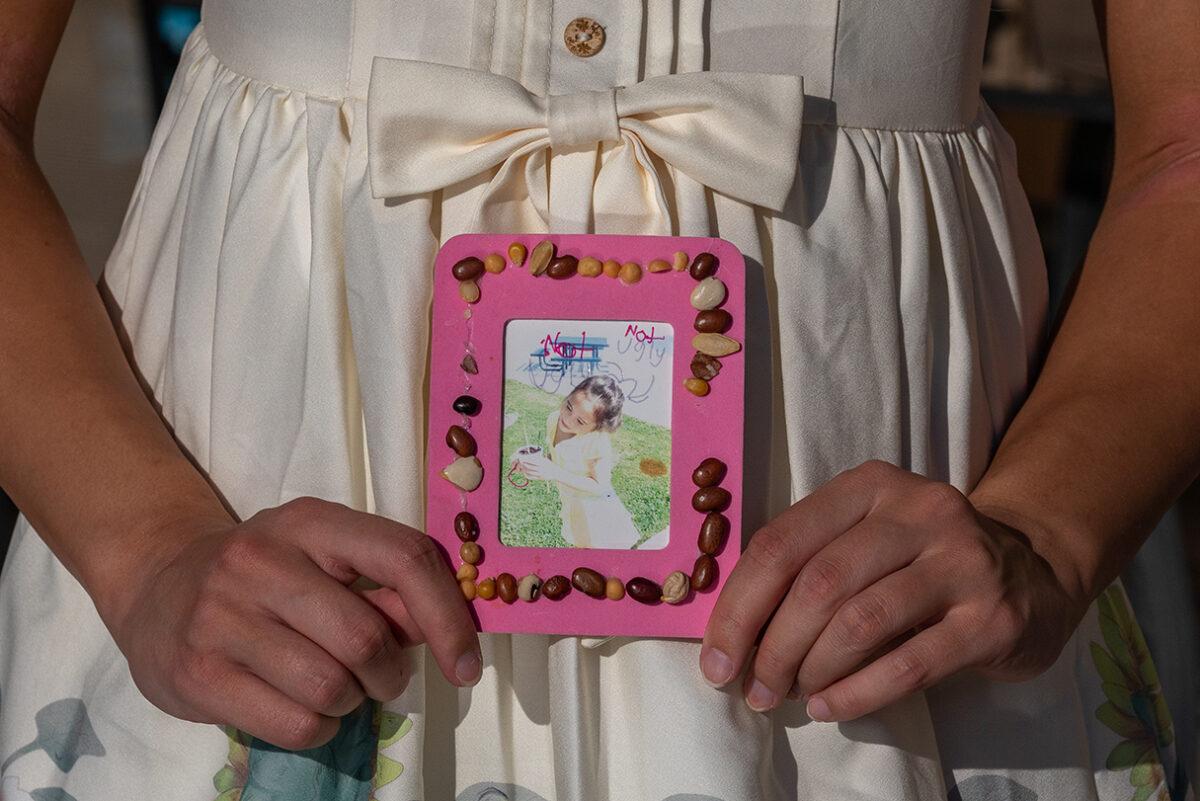 Chloe Cole holds a childhood photo in Northern California on Aug. 26, 2022. (John Fredricks/The Epoch Times)