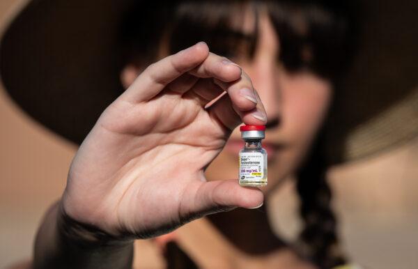  Chloe Cole, an 18-year-old woman who regrets surgically removing her breasts, holds testosterone medication used for transgender patients, in Northern California on Aug. 26, 2022. (John Fredricks/The Epoch Times)