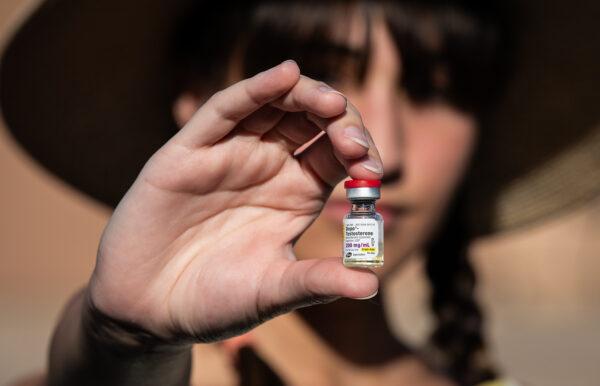 Chloe Cole, an 18-year-old woman who regrets surgically removing her breasts, holds testosterone medication used for transgender patients in Northern California on Aug. 26, 2022. (John Fredricks/The Epoch Times)