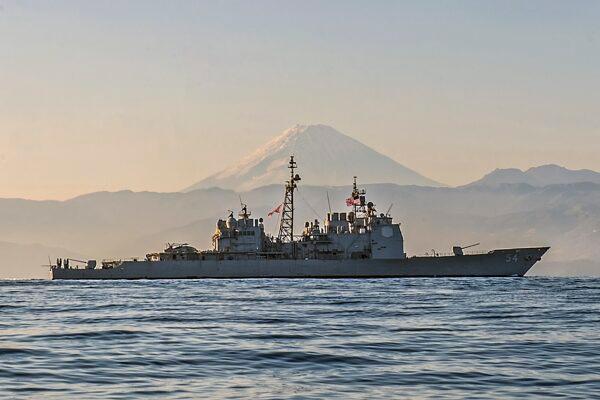 Guided-missile cruiser USS Antietam (CG 54), here steaming off the coast of Japan with Mt. Fuji shimmering in the distance, is among 17 Ticonderoga-class cruisers the Navy wants to mothball but the House wants to keep in service for at least several more years. (Mass Communication Specialist Seaman David Flewellyn/U.S. Navy via AP)