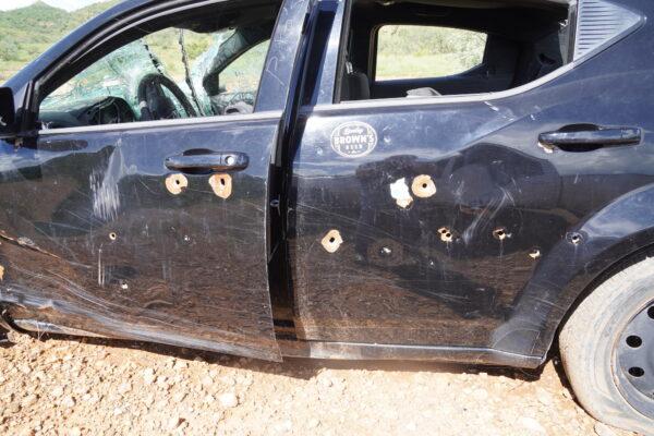A vehicle shot full of bullet holes lies just beyond the border wall fence east of Arivaca, Ariz., on Aug. 25, 2022. (Allan Stein/The Epoch Times)