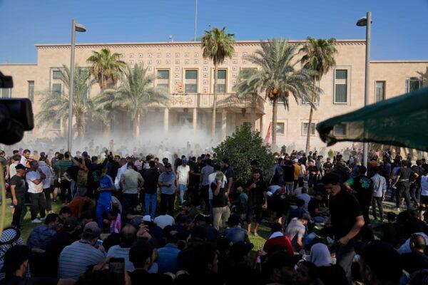 Iraqi security forces fire tear gas on followers of Shiite cleric Muqtada al-Sadr protesting inside the government palace grounds in Baghdad on Aug. 29, 2022. (Hadi Mizban/AP Photo)